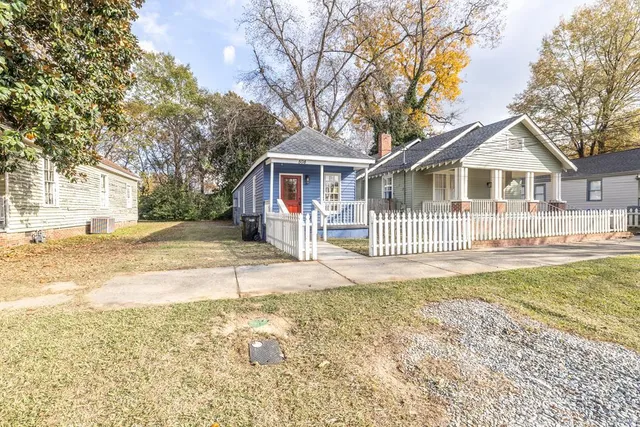 a view of a house with a yard and large tree