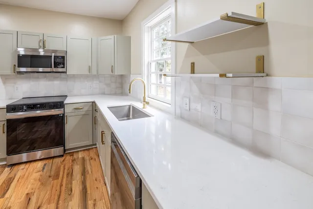 a kitchen with a sink a microwave and cabinets