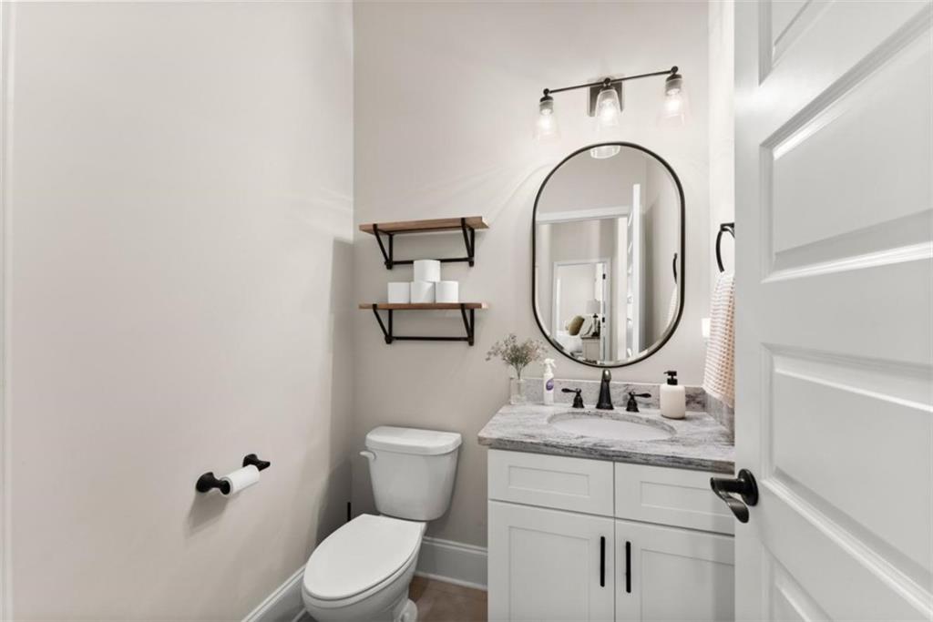 845 Walnut River Trail Hoschton, GA 30548 - Photo 14 of 74 a bathroom with a granite countertop toilet a sink and a mirror