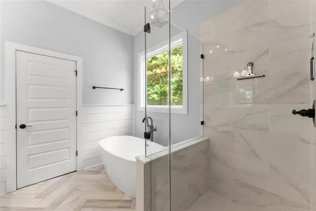 a view of a dining room and livingroom with furniture wooden floor a chandelier