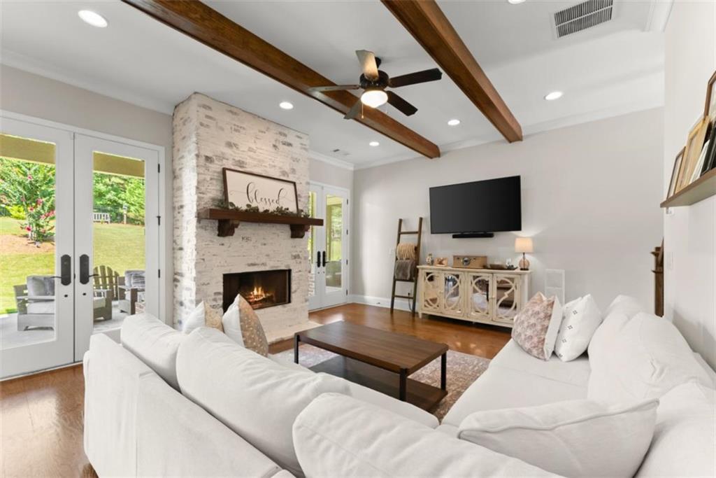 845 Walnut River Trail Hoschton, GA 30548 - Photo 25 of 74 a living room with furniture a fireplace and a flat screen tv