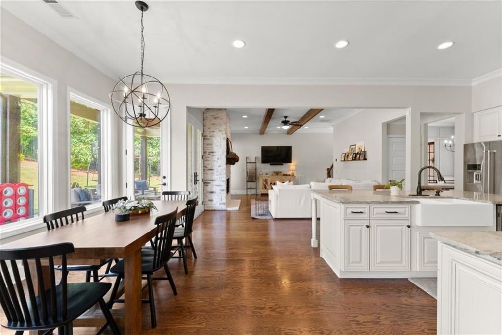 845 Walnut River Trail Hoschton, GA 30548 - Photo 30 of 74 a view of a dining room and livingroom with furniture wooden floor a chandelier