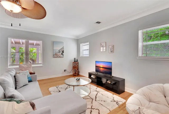 a living room with furniture a window and a flat screen tv