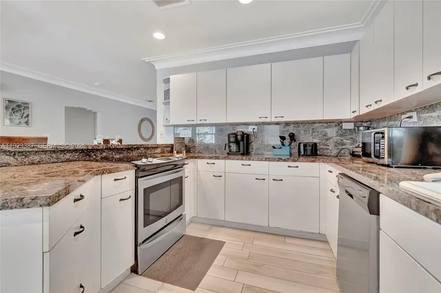 a kitchen with granite countertop white cabinets and white appliances