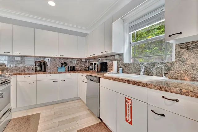 a kitchen with granite countertop white cabinets and white appliances