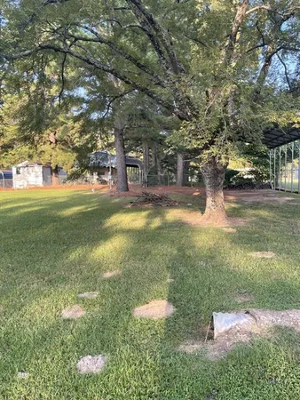 a view of yard with swimming pool and trees