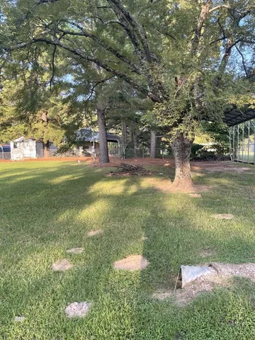 a view of yard with swimming pool and trees