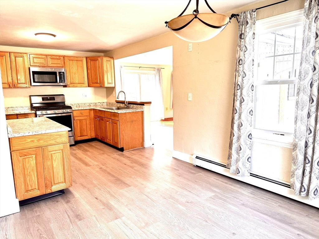 9 Redfield Road Cherry Valley, MA 01611 - Photo 17 of 35 a kitchen with stainless steel appliances granite countertop a refrigerator a stove top oven a sink and dishwasher with wooden floor