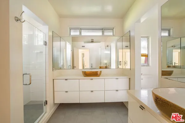 a bathroom with a double vanity sink mirror and shower