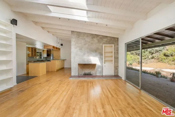 a view of a livingroom with a fireplace and window