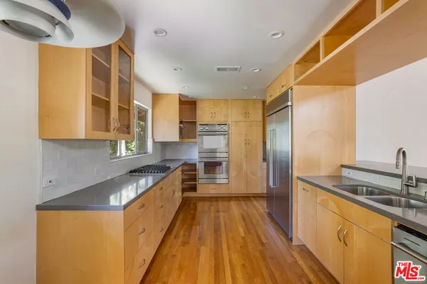a kitchen with stainless steel appliances granite countertop a sink and wooden cabinets