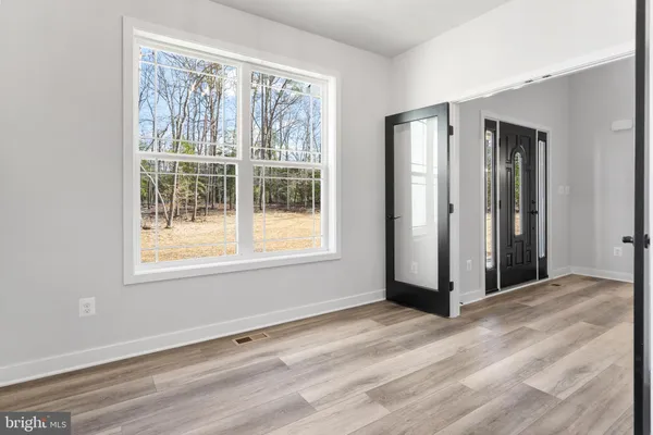 a view of a kitchen with stainless steel appliances kitchen island granite countertop a refrigerator and cabinets