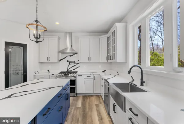 a kitchen with stainless steel appliances granite countertop a sink a stove and a window