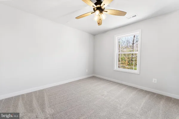 a view of a bedroom with closet and a ceiling fan