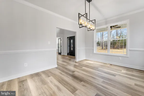 a view of empty room with wooden floor and window