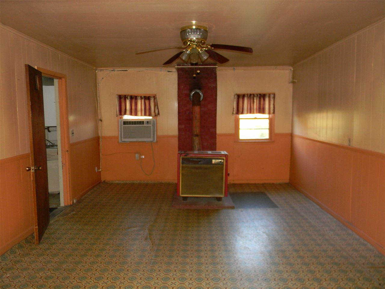 The living room connects the kitchen and the bedrooms.  The home does have electricity.