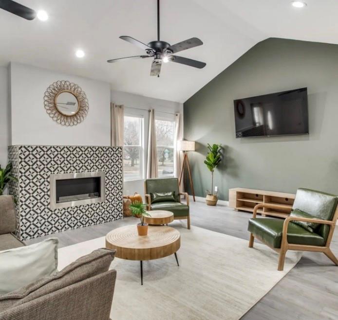1606 West 12th Street Dallas, TX 75208 - Photo 4 of 20 Living area with vaulted ceiling, a tiled fireplace, recessed lighting, wood finished floors, and a ceiling fan