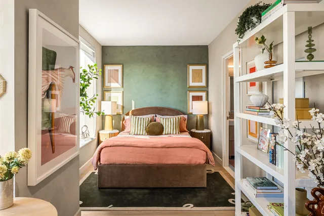 a bedroom with a bed a bookshelf and a potted plant