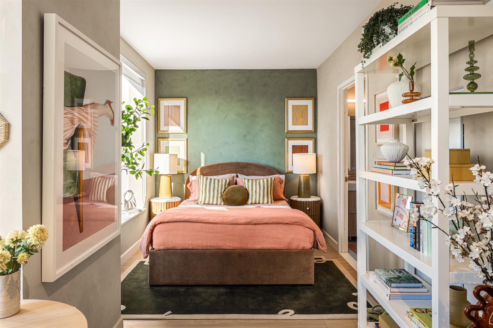 a bedroom with a bed a bookshelf and a potted plant