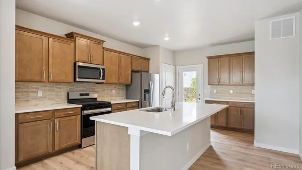 a kitchen with stainless steel appliances a sink stove refrigerator and cabinets