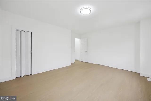 an empty room with a white cabinet and a window