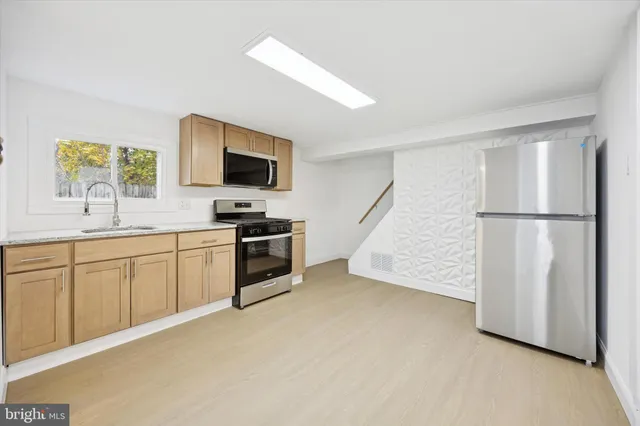 a kitchen with sink cabinets and stainless steel appliances