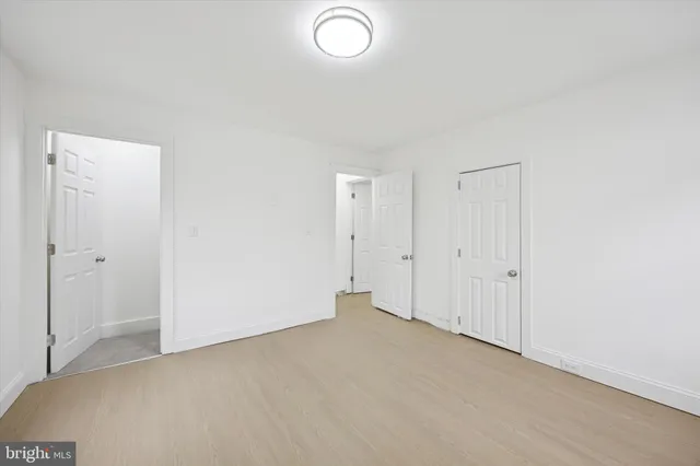 an empty room with closet area and a window