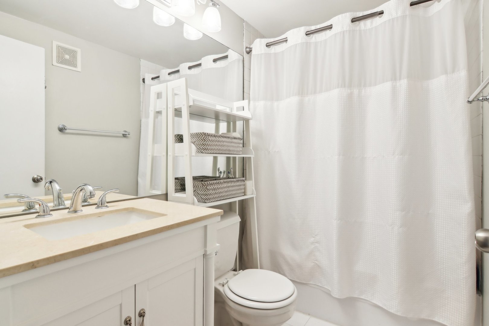 226 North Clinton Street, Unit 216 Chicago, IL 60661 - Photo 12 of 21 a bathroom with a sink a toilet a mirror and shower curtain
