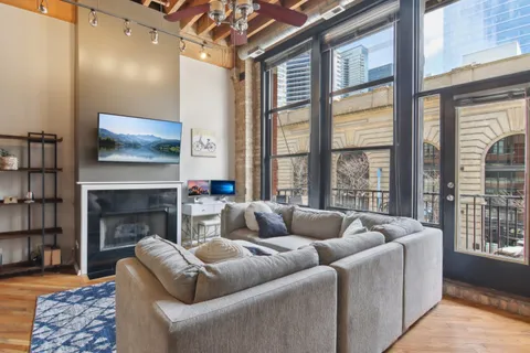 a living room with furniture a fireplace and a large window