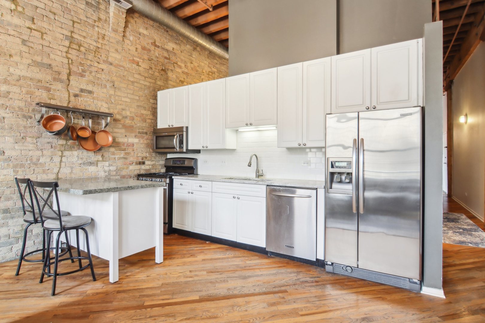 226 North Clinton Street, Unit 216 Chicago, IL 60661 - Photo 7 of 21 a kitchen with a refrigerator sink and cabinets