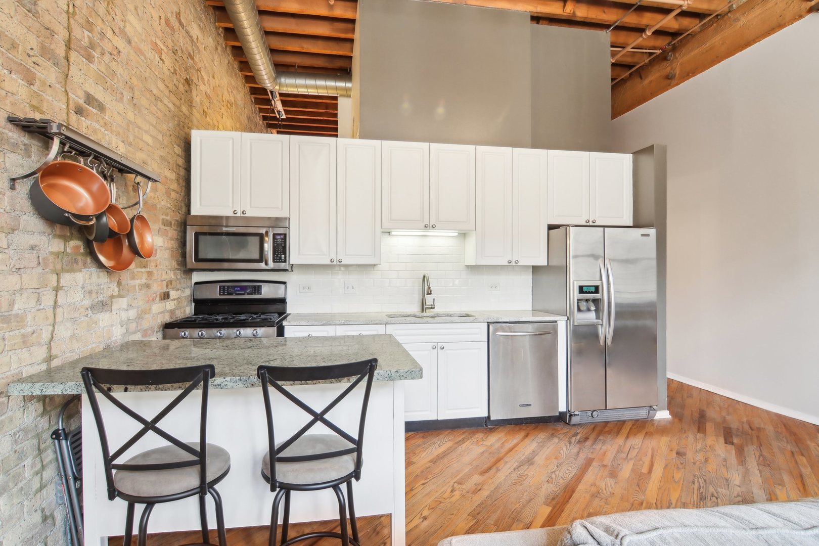 226 North Clinton Street, Unit 216 Chicago, IL 60661 - Photo 8 of 21 a kitchen with stainless steel appliances a stove a sink refrigerator and a microwave