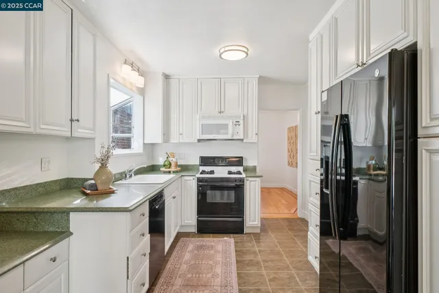 a kitchen with stainless steel appliances granite countertop a sink stove and cabinets