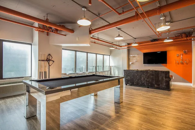 a living room with stainless steel appliances kitchen island granite countertop a sink and wooden floor