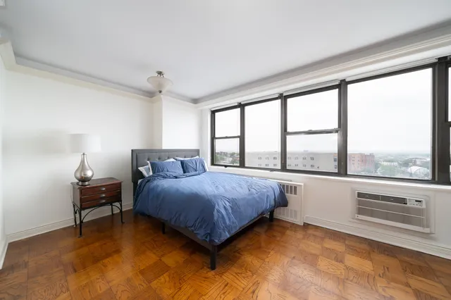 a bedroom with a bed and a large window