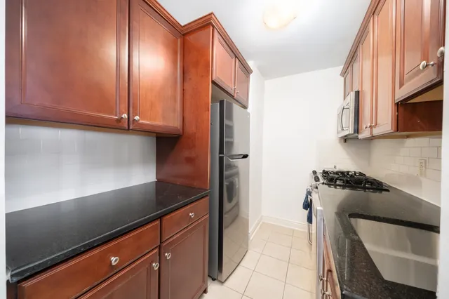 a kitchen with stainless steel appliances granite countertop a sink stove and cabinets