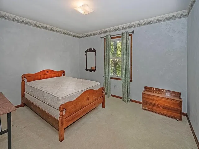 a bed sitting in a bedroom next to a window