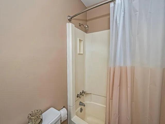 a bathroom with a shower curtain and a toilet