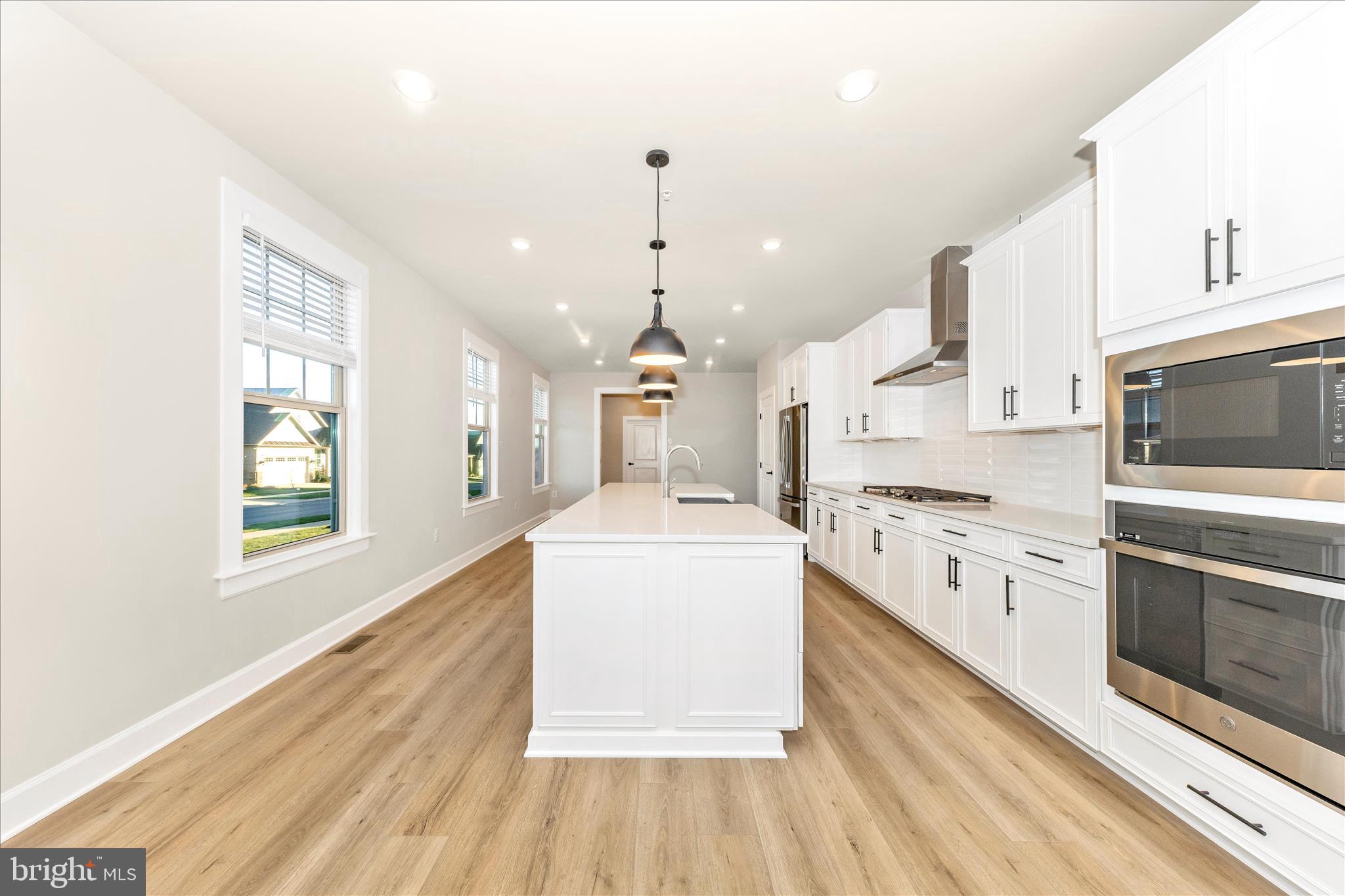 413 Bucklebury Lane Frederick, MD 21702 - Photo 11 of 58 a large kitchen with granite countertop a white stove top oven sink and cabinets