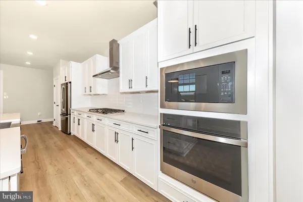 a kitchen with stainless steel appliances white cabinets and a granite counter tops