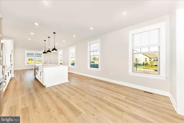 a large white kitchen with white cabinets and wooden floor