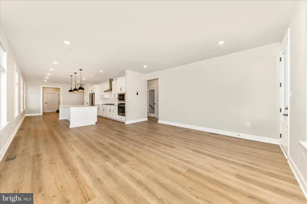 a kitchen with stainless steel appliances kitchen island wooden floors and white cabinets