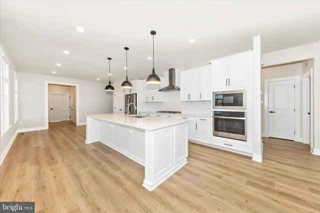 a large kitchen with granite countertop a white stove top oven sink and cabinets