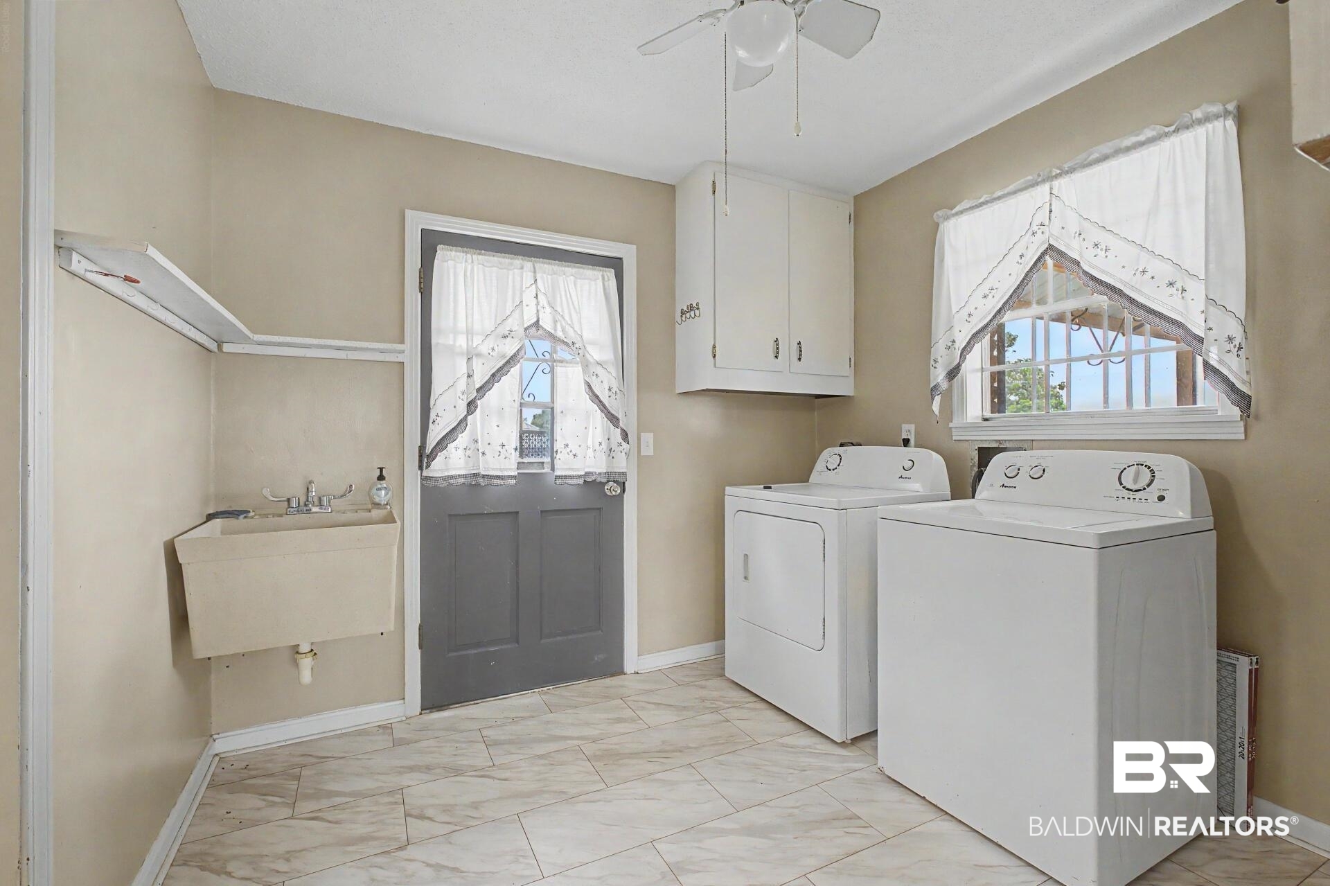 3791 Robinsonville Road Atmore, AL 36502 - Photo 22 of 47 Utility room featuring patterned tile flooring, a built-in utility sink, upper cabinetry, and a ceiling fan