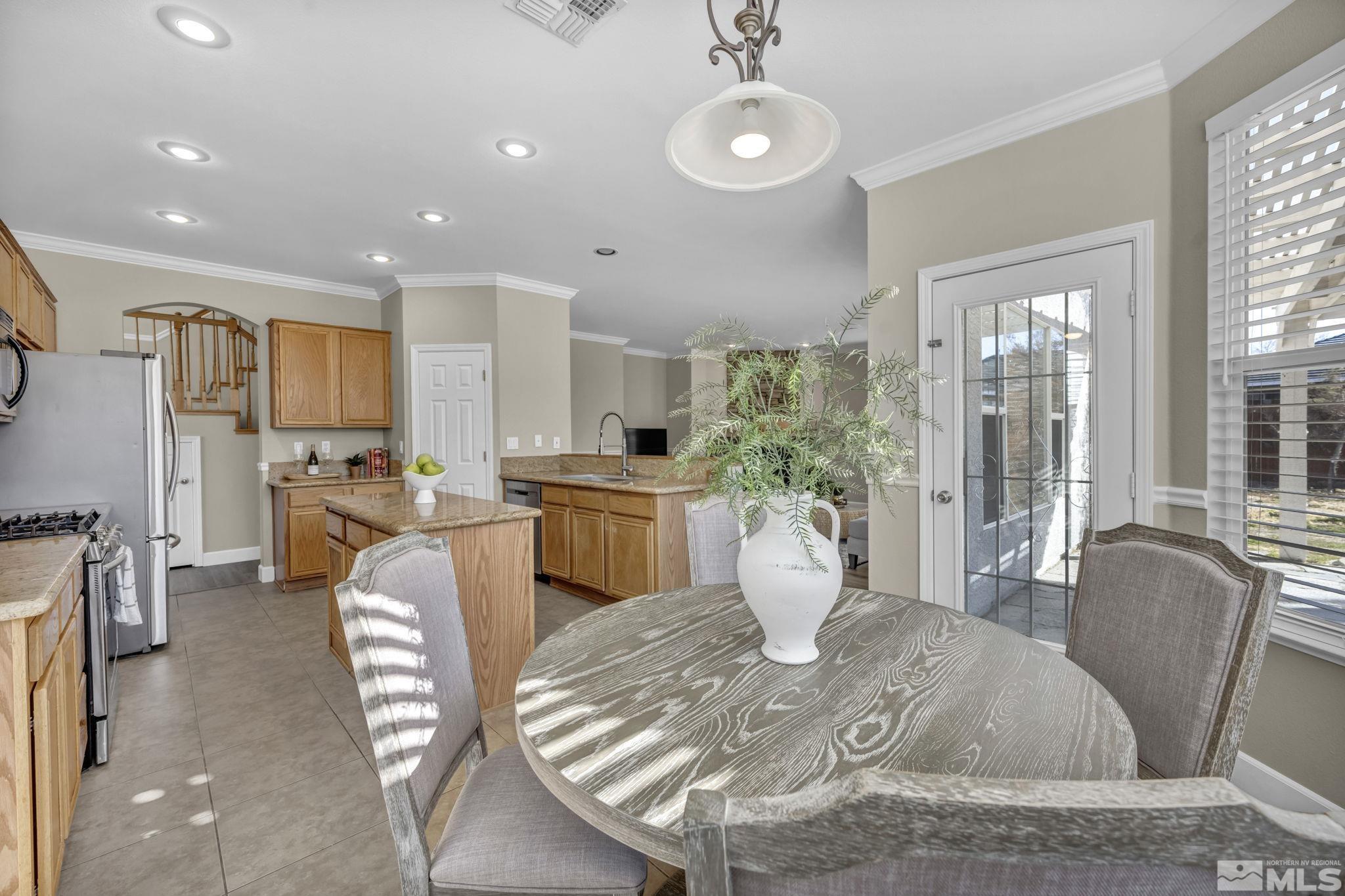9765 Rolling Rock Court Reno, NV 89521 - Photo 12 of 39 a dining room with furniture a large window and stainless steel appliances