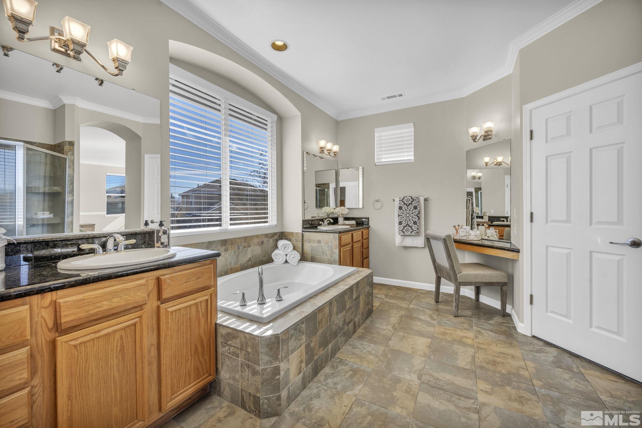 9765 Rolling Rock Court Reno, NV 89521 - Photo 21 of 39 a large kitchen with kitchen island white cabinets and stainless steel appliances