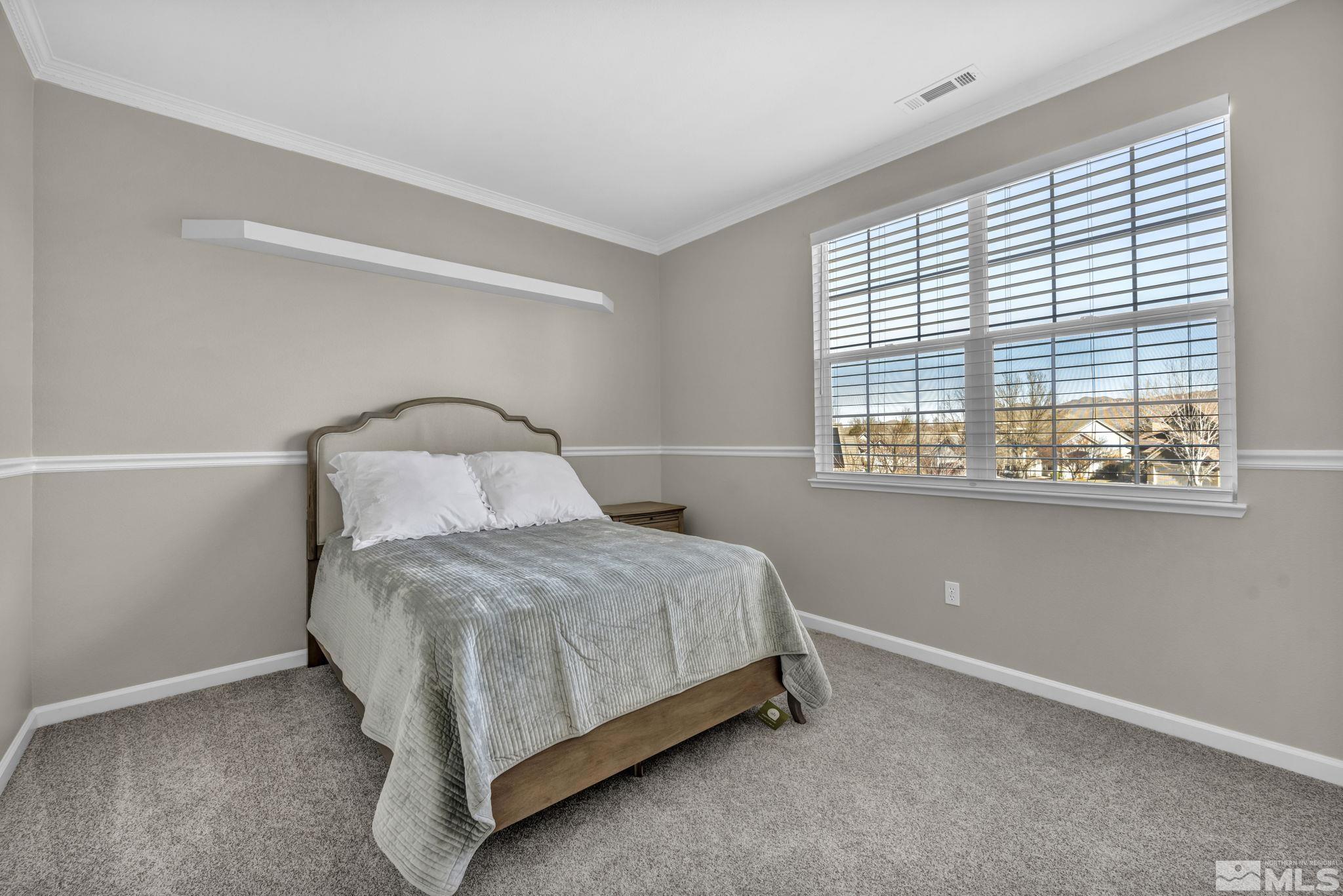 9765 Rolling Rock Court Reno, NV 89521 - Photo 22 of 39 a bedroom with a bed and window