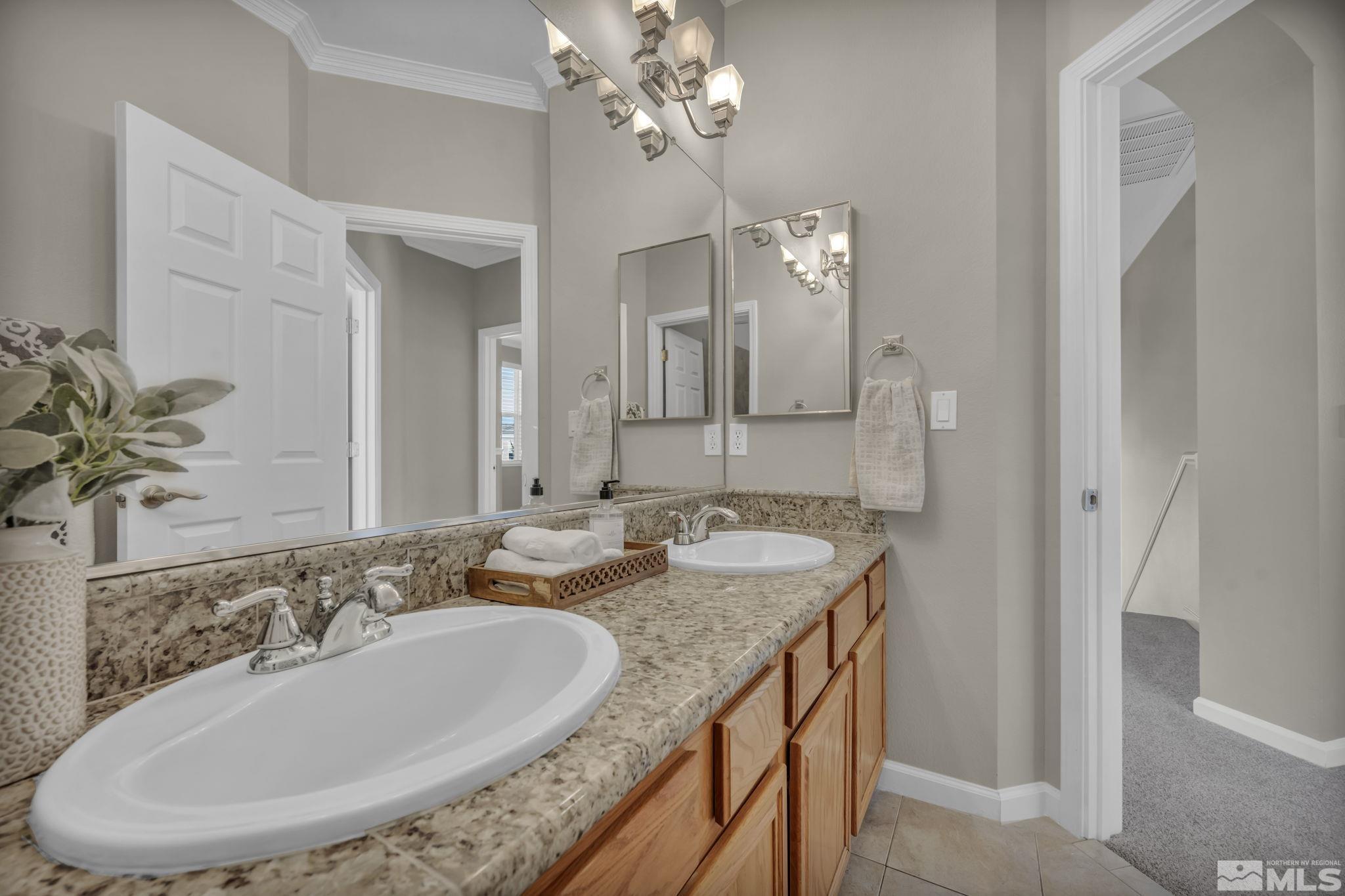 9765 Rolling Rock Court Reno, NV 89521 - Photo 24 of 39 a bathroom with a granite countertop sink a large mirror and a shower
