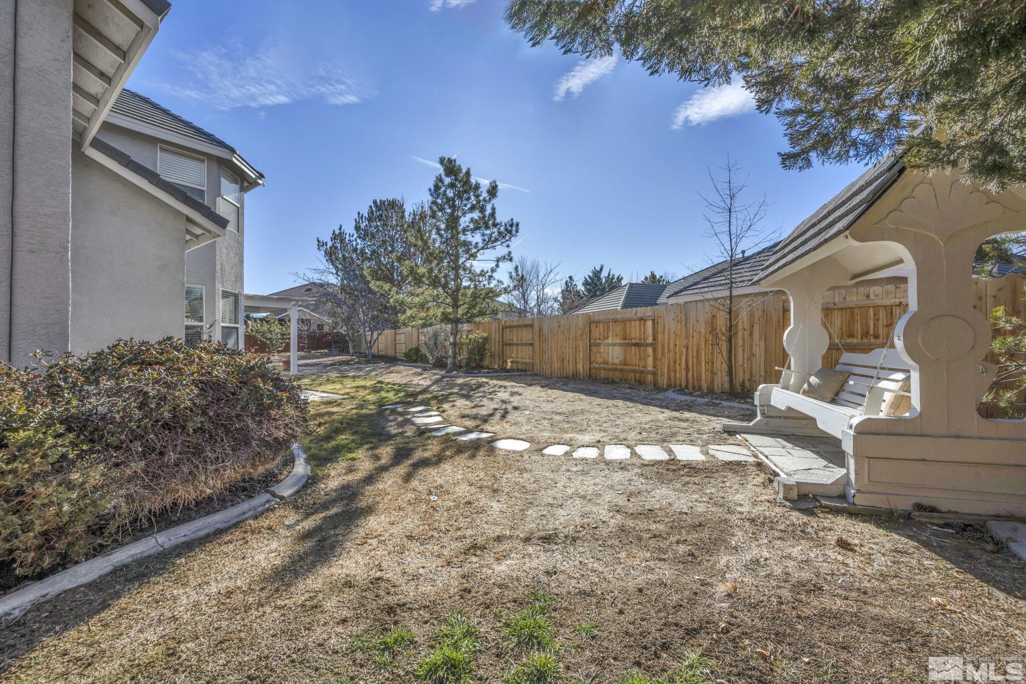 9765 Rolling Rock Court Reno, NV 89521 - Photo 26 of 39 a view of a backyard with large trees and wooden fence