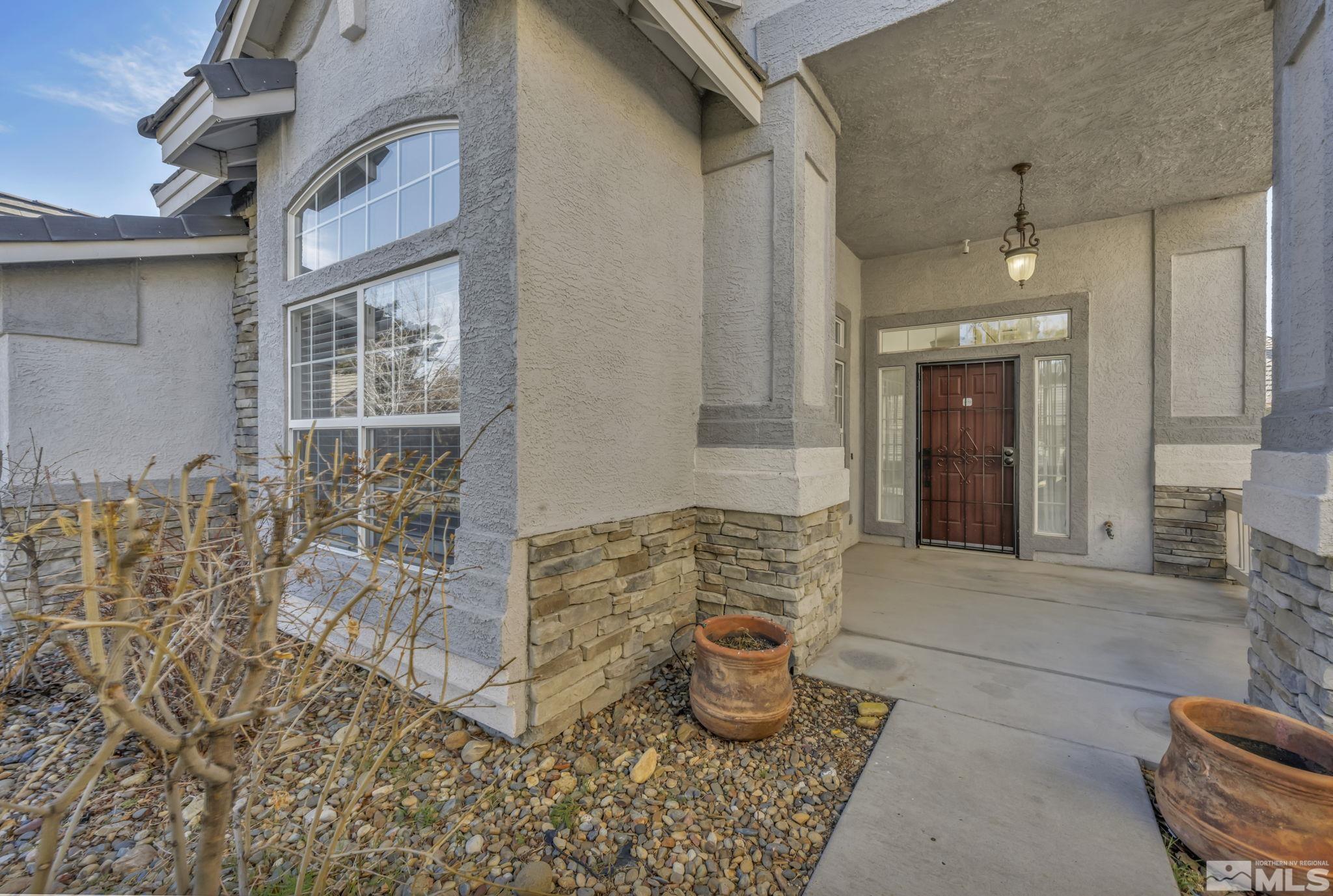 9765 Rolling Rock Court Reno, NV 89521 - Photo 3 of 39 a front view of a house with outdoor seating