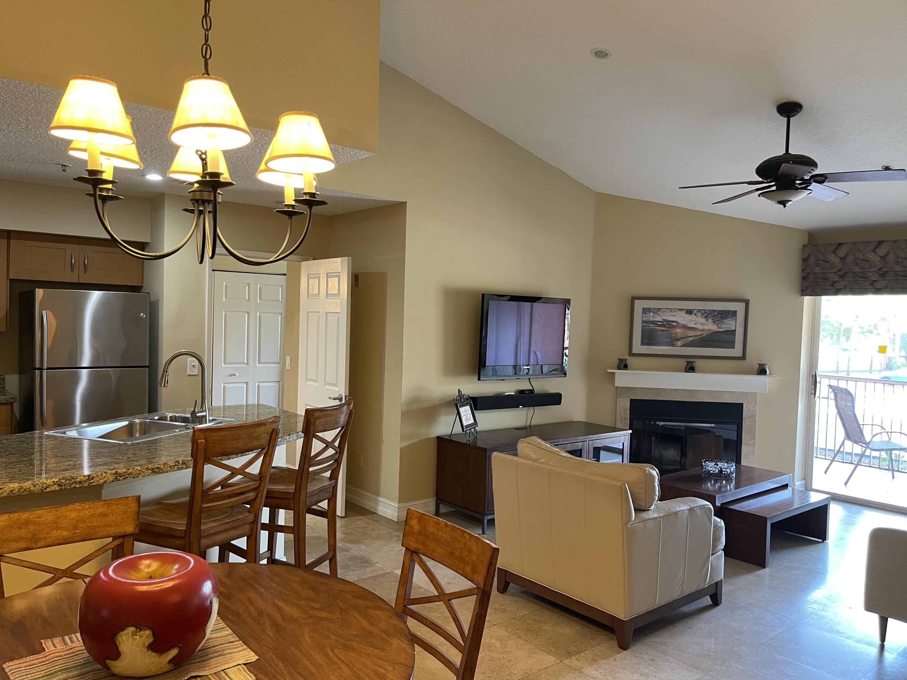 3111 Clint Moore Road, Unit 205 Boca Raton, FL 33496 - Photo 15 of 35 a living room with furniture a fireplace and a chandelier